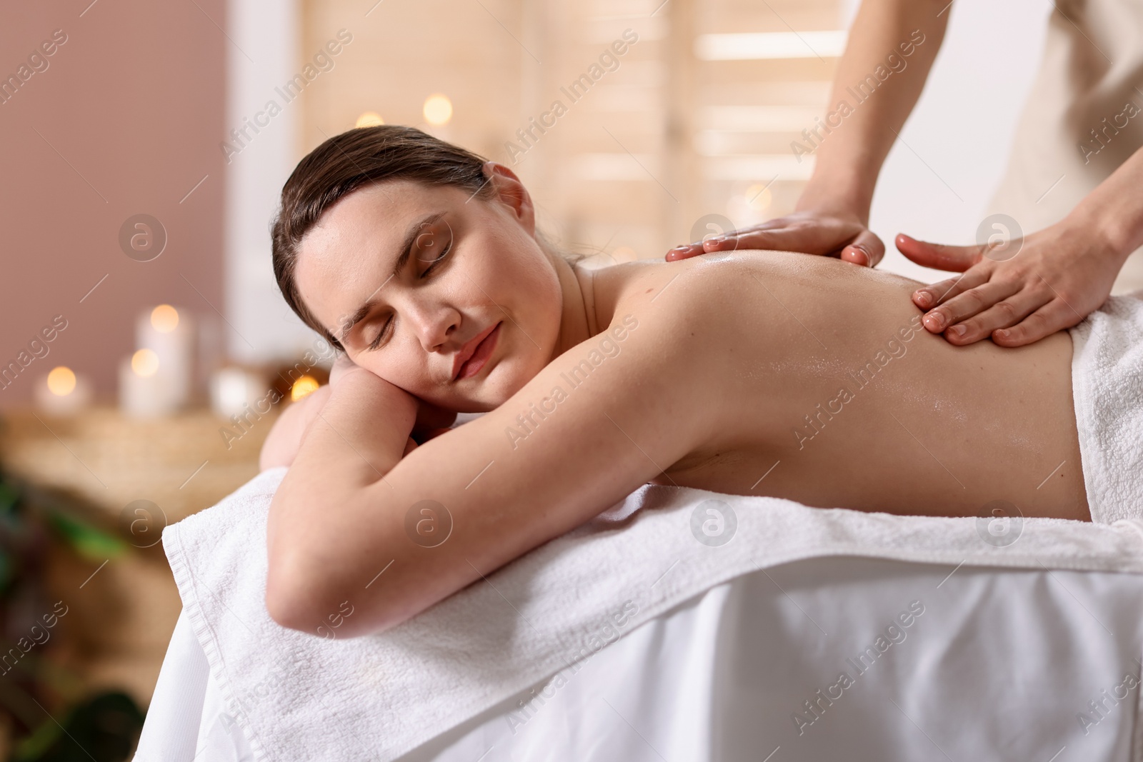 Woman receiving back massage with oil in spa salon Photo of Woman receiving back massage with oil in spa salon