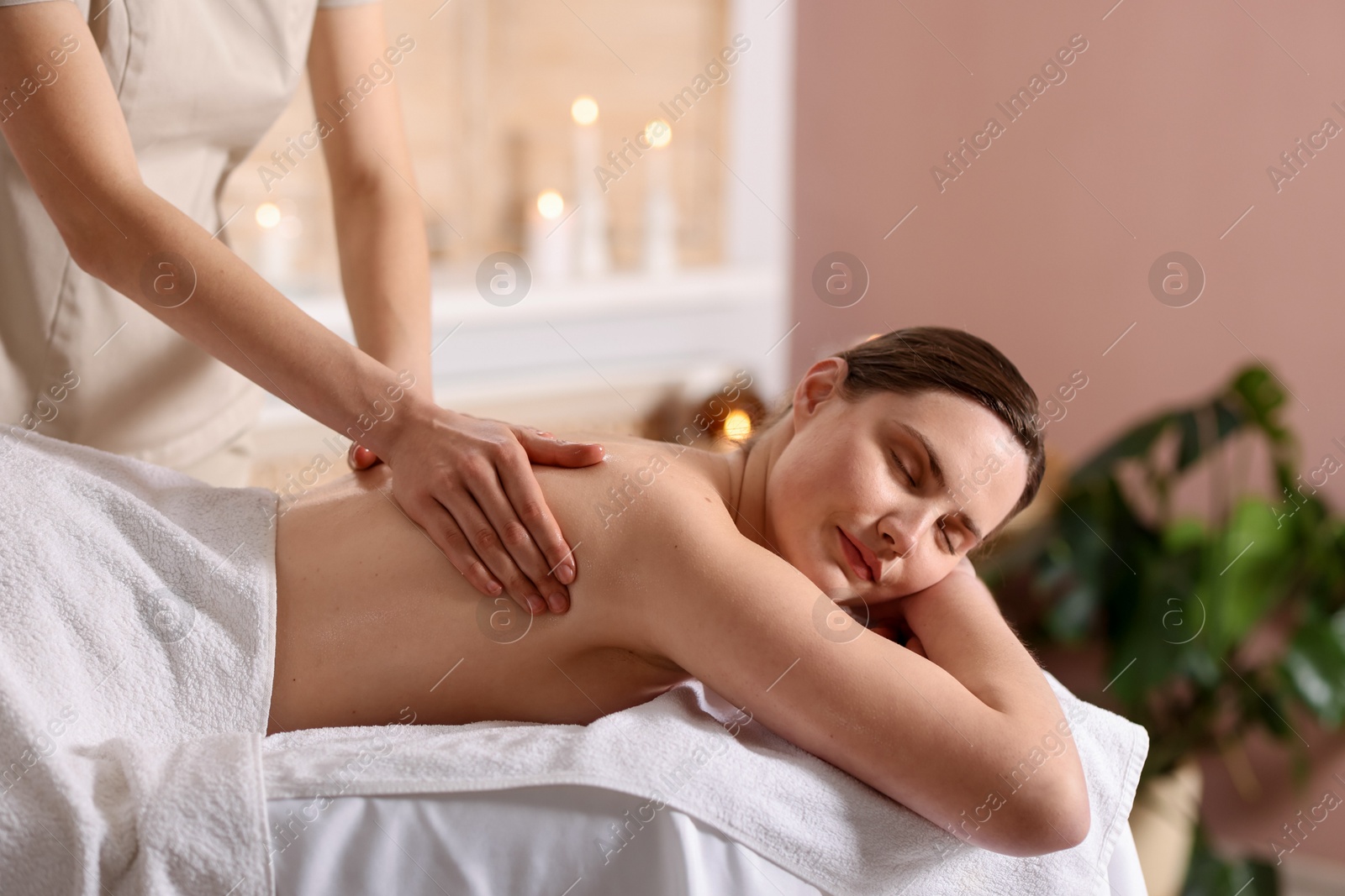 Woman receiving back massage with oil in spa salon Photo of Woman receiving back massage with oil in spa salon