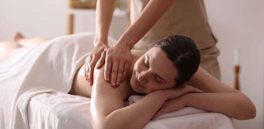 Photo of Woman receiving back massage with oil in spa salon