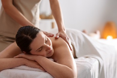 Photo of Woman receiving back massage with oil in spa salon, space for text