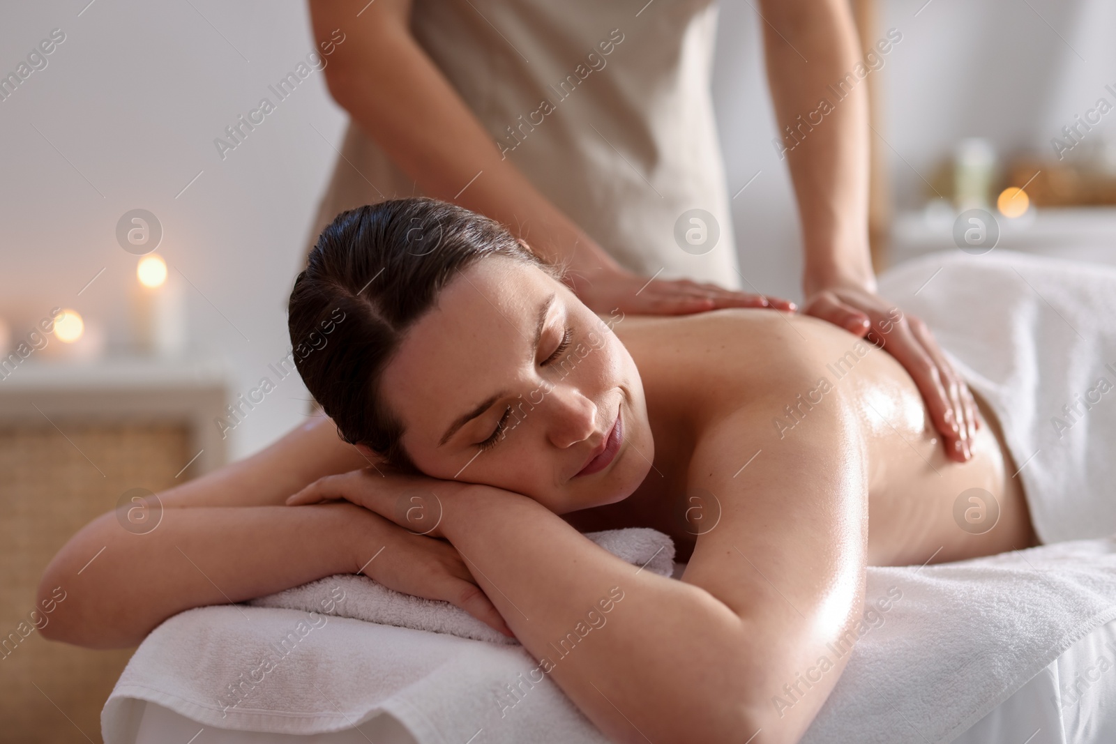 Woman receiving back massage with oil in spa salon Photo of Woman receiving back massage with oil in spa salon