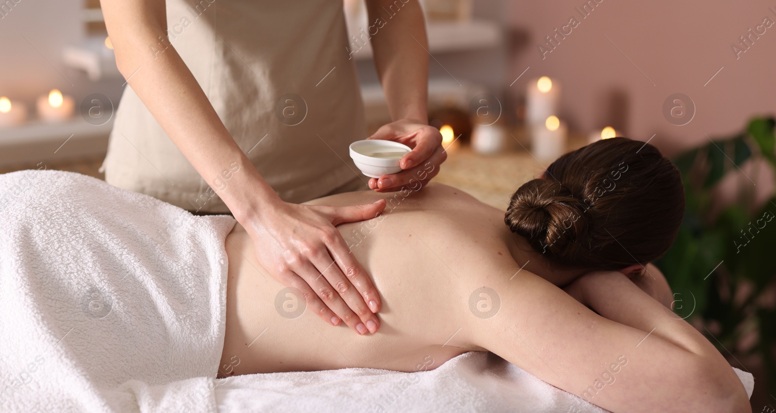 Woman receiving back massage with oil in spa salon Photo of Woman receiving back massage with oil in spa salon