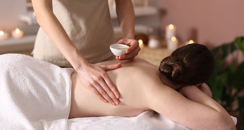 Photo of Woman receiving back massage with oil in spa salon
