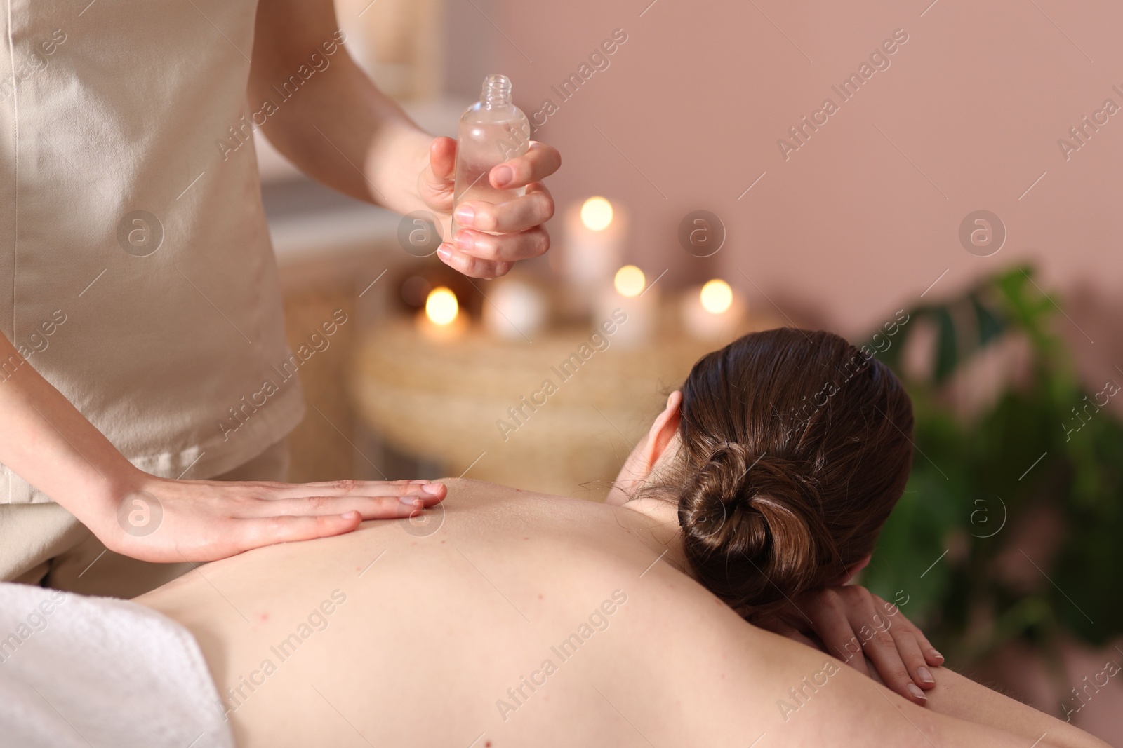 Woman receiving back massage with oil in spa salon Photo of Woman receiving back massage with oil in spa salon