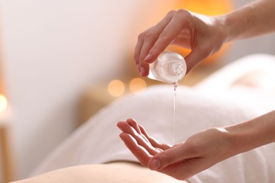 Photo of Woman receiving back massage with oil in spa salon, closeup
