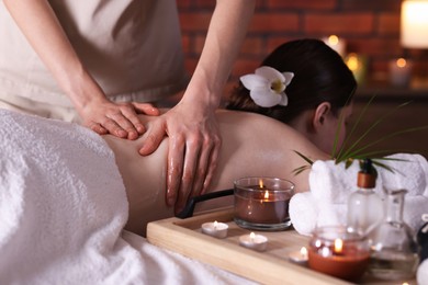 Photo of Woman receiving back massage with oil in spa salon