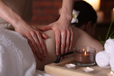 Photo of Woman receiving back massage with oil in spa salon