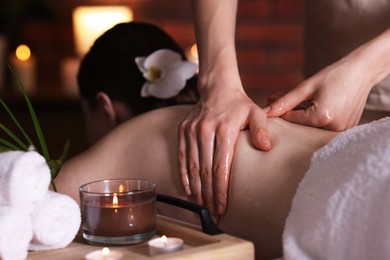 Photo of Woman receiving back massage with oil in spa salon