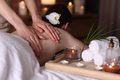 Photo of Woman receiving back massage with oil in spa salon