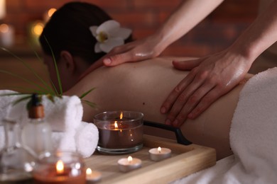 Photo of Woman receiving back massage with oil in spa salon