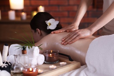 Photo of Woman receiving back massage with oil in spa salon