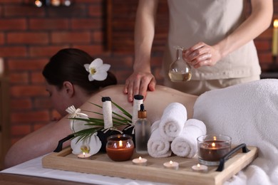 Photo of Woman receiving back massage with oil in spa salon
