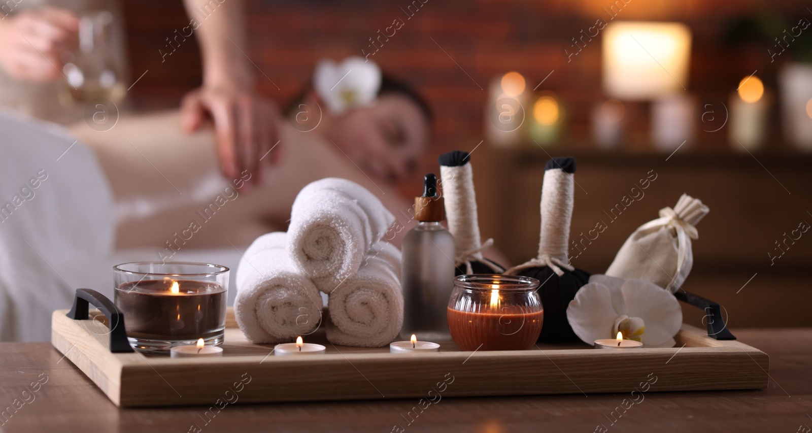Woman receiving back massage with oil indoors, focus on different spa supplies Photo of Woman receiving back massage with oil indoors, focus on different spa supplies