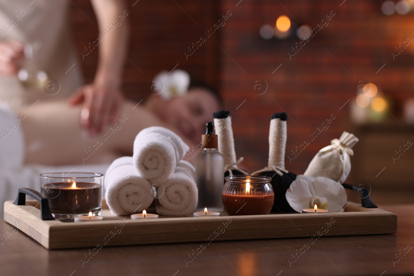 Woman receiving back massage with oil indoors, focus on different spa supplies Photo of Woman receiving back massage with oil indoors, focus on different spa supplies