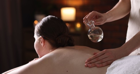 Photo of Woman receiving back massage with oil in spa salon