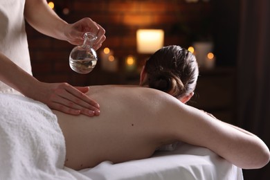 Photo of Woman receiving back massage with oil in spa salon