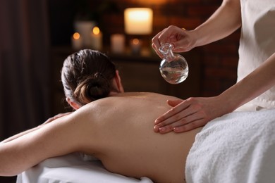 Photo of Woman receiving back massage with oil in spa salon