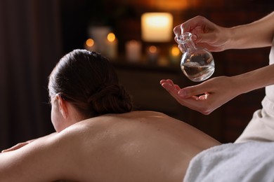 Photo of Woman receiving back massage with oil in spa salon