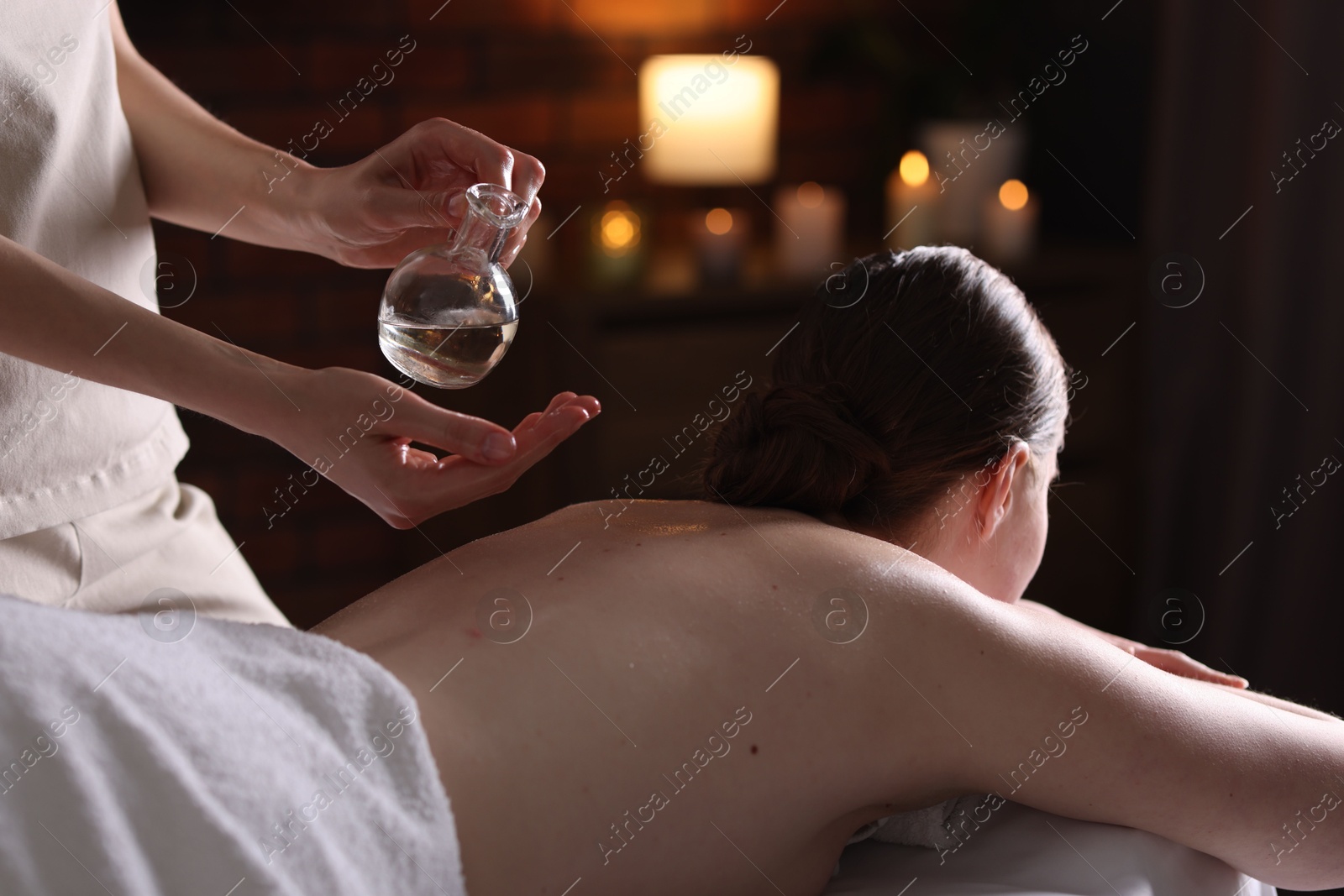 Woman receiving back massage with oil in spa salon Photo of Woman receiving back massage with oil in spa salon