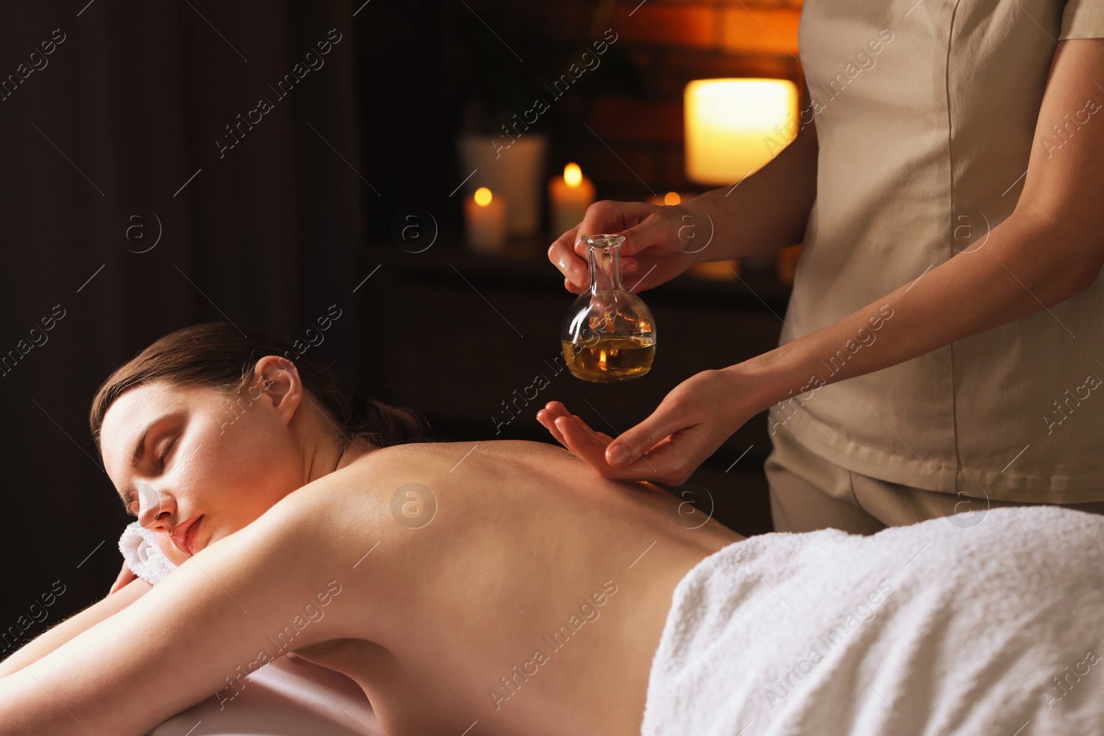 Woman receiving back massage with oil in spa salon Photo of Woman receiving back massage with oil in spa salon