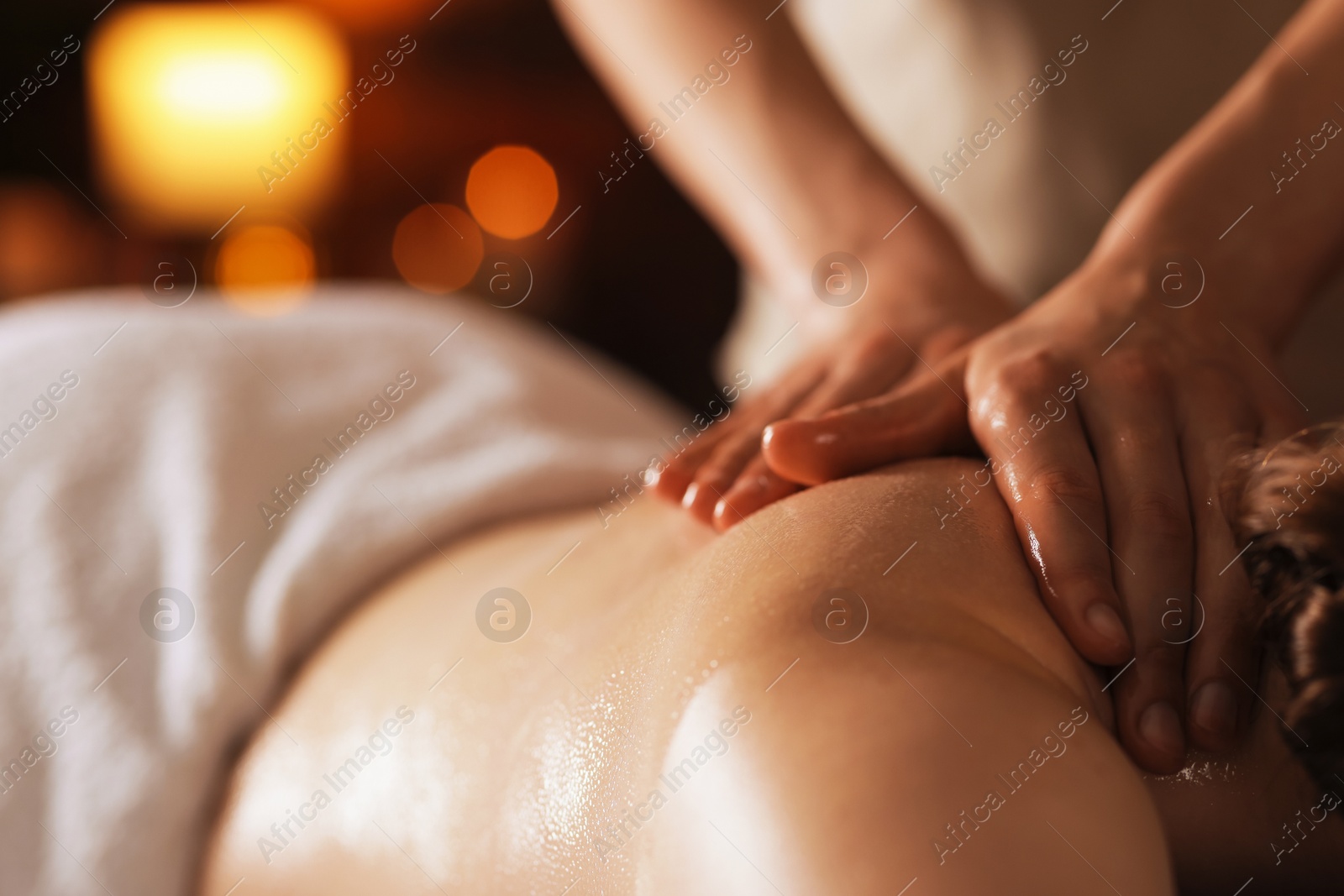 Photo of Woman receiving back massage with oil in spa salon, closeup