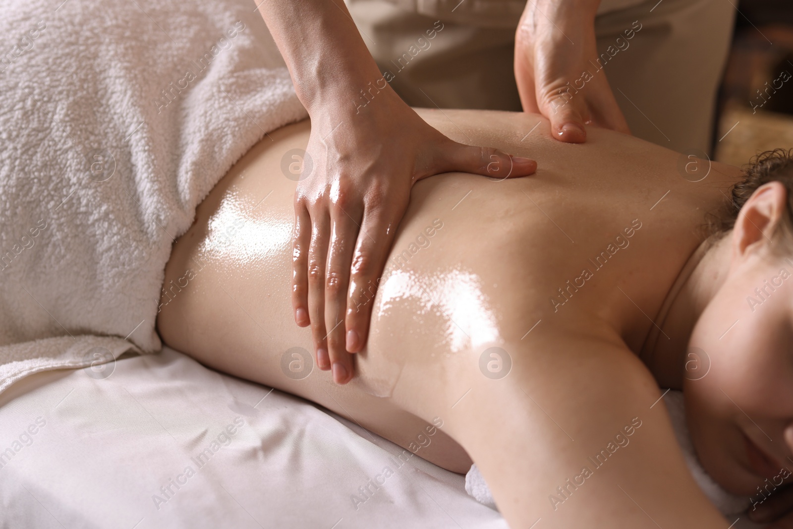 Woman receiving back massage with oil in spa salon, closeup Photo of Woman receiving back massage with oil in spa salon, closeup
