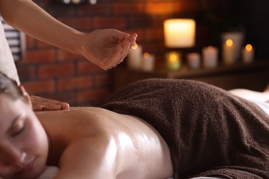 Photo of Woman receiving back massage with oil in spa salon, closeup