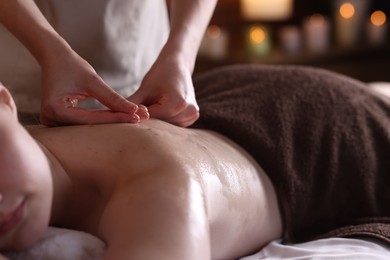 Photo of Woman receiving back massage with oil in spa salon, closeup
