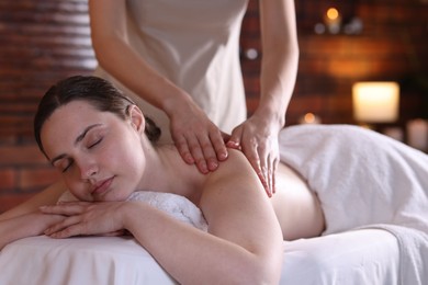 Photo of Woman receiving back massage with oil in spa salon