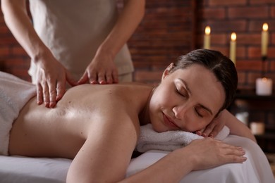 Photo of Woman receiving back massage with oil in spa salon