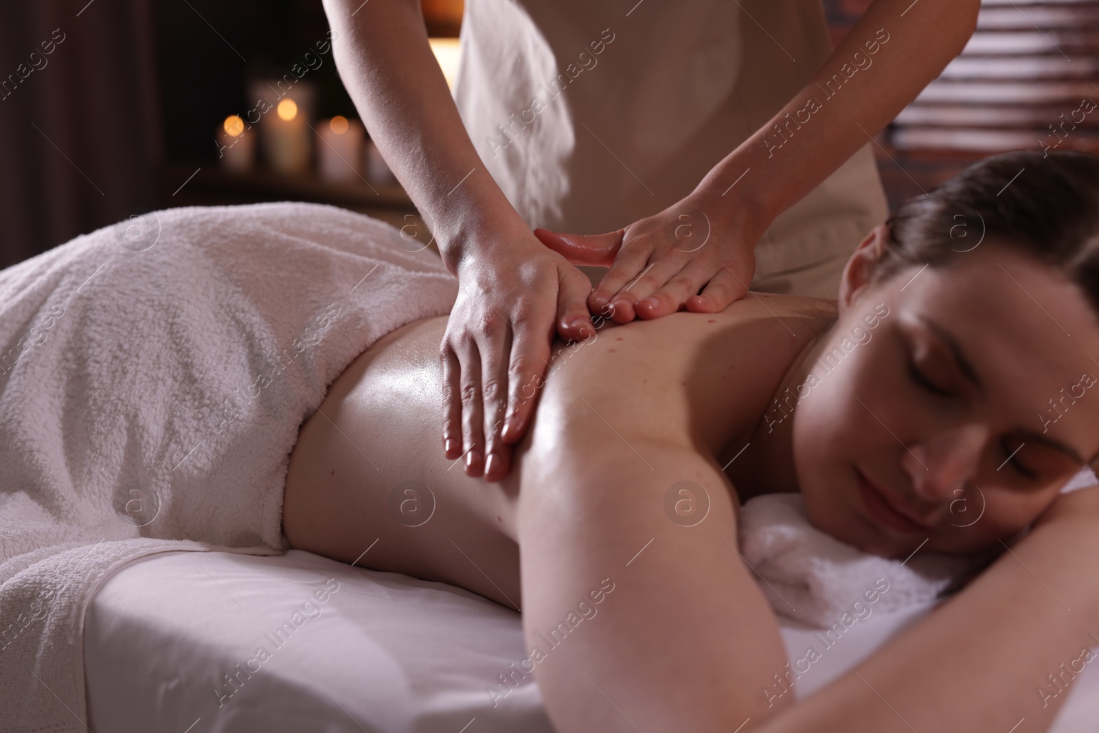 Woman receiving back massage with oil in spa salon Photo of Woman receiving back massage with oil in spa salon
