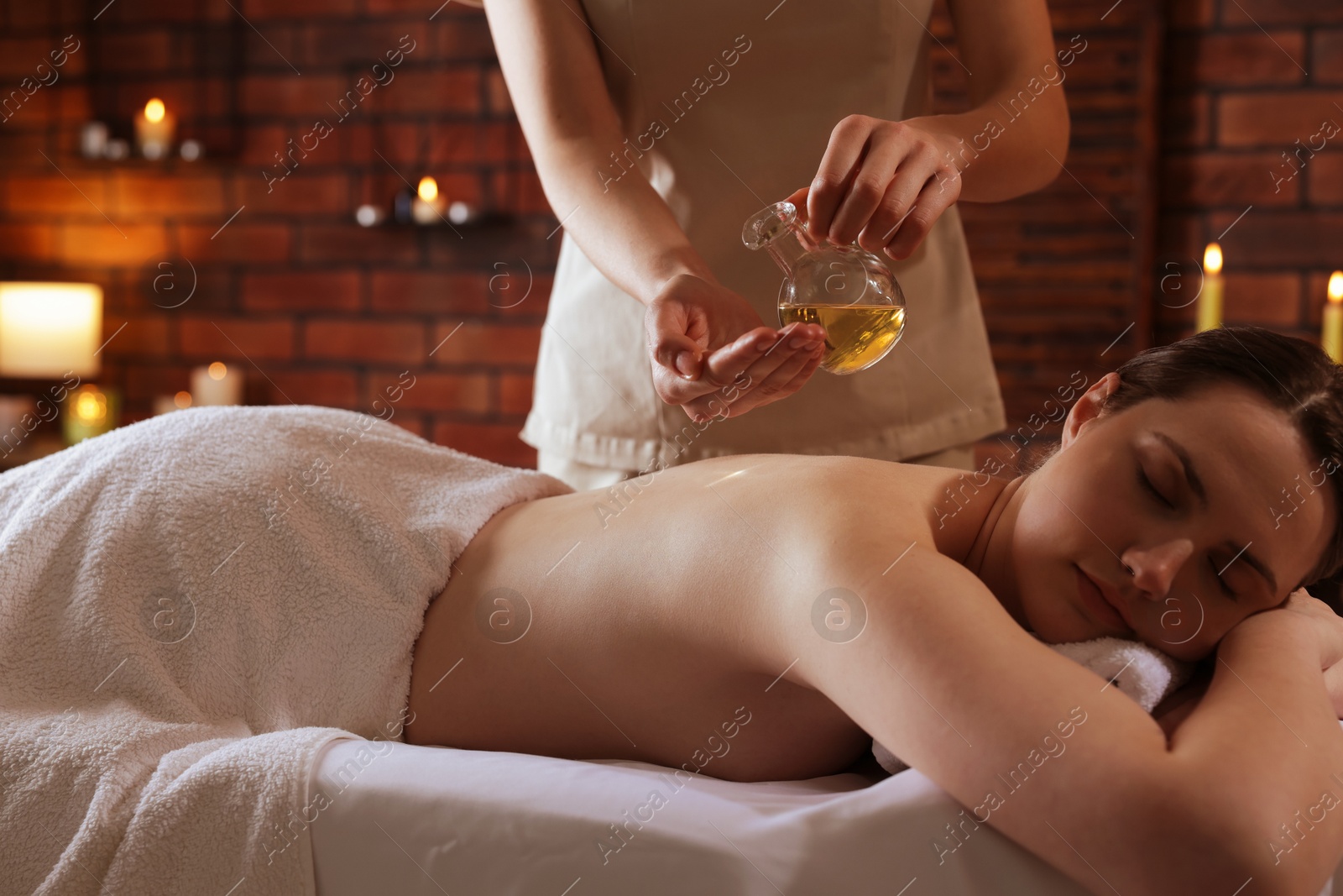 Woman receiving back massage with oil in spa salon Photo of Woman receiving back massage with oil in spa salon