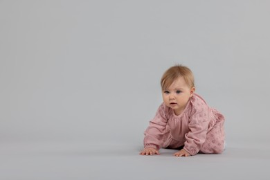 Photo of Cute little baby crawling on light grey background, space for text