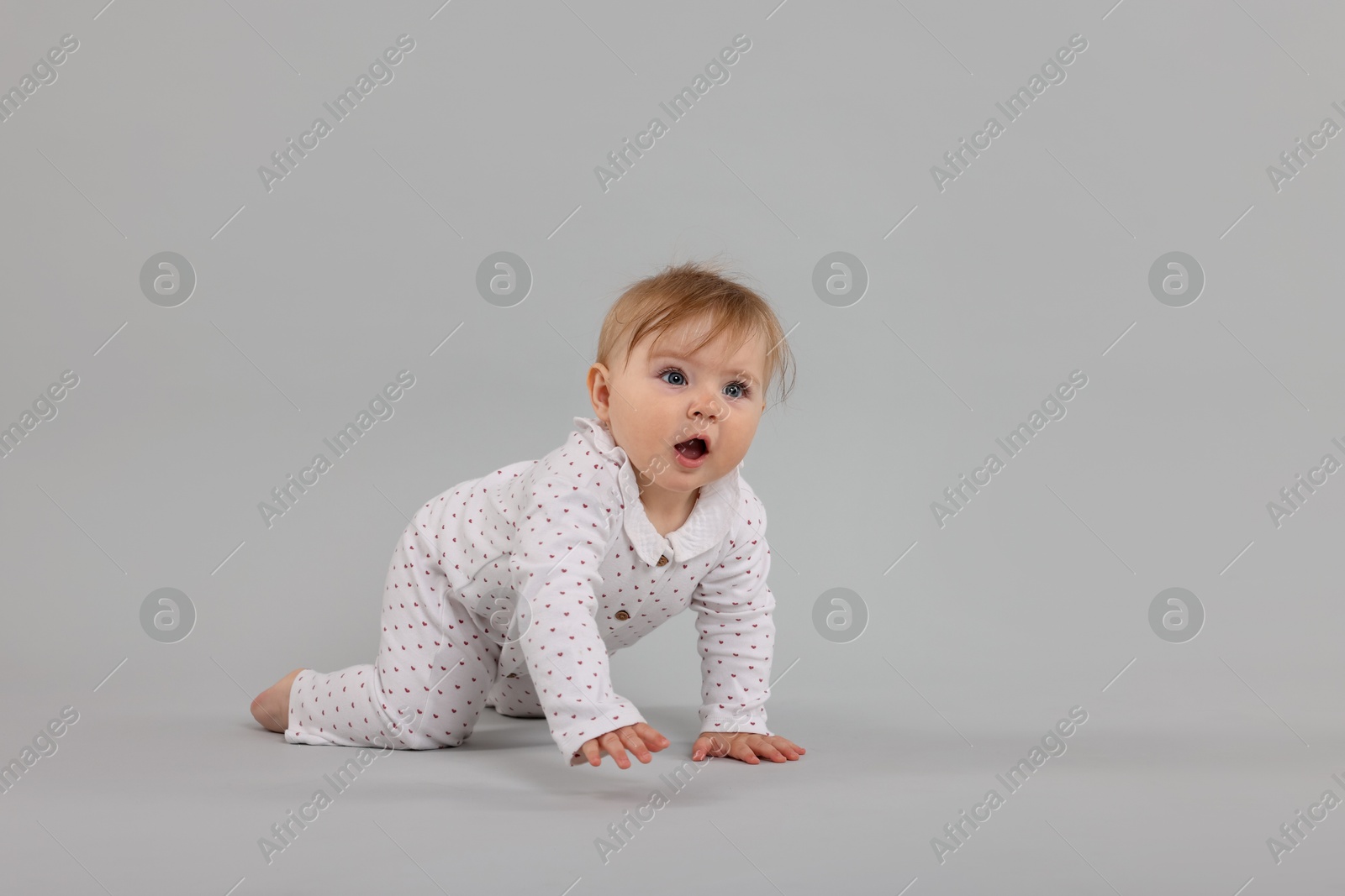 Cute little baby crawling on light grey background, space for text Photo of Cute little baby crawling on light grey background, space for text