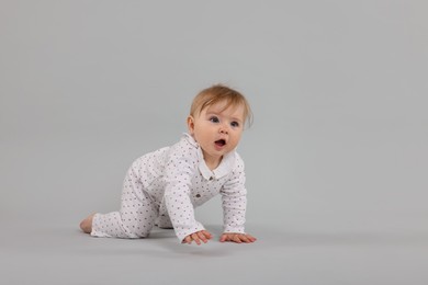 Photo of Cute little baby crawling on light grey background, space for text