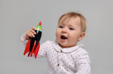 Photo of Cute little baby playing with toy on light grey background