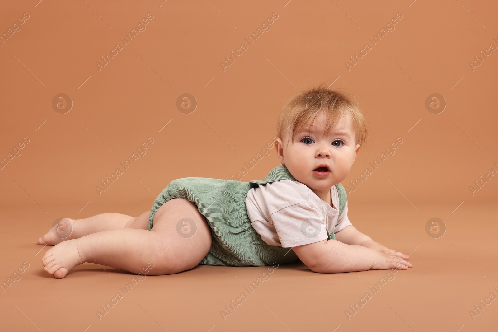 Portrait of cute little baby on pale brown background Photo of Portrait of cute little baby on pale brown background