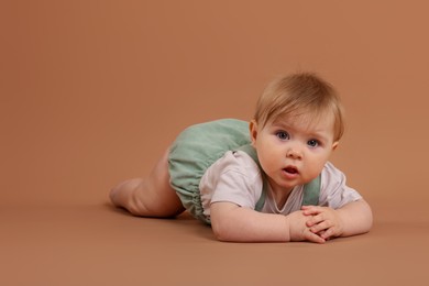 Photo of Cute little baby on pale brown background, space for text