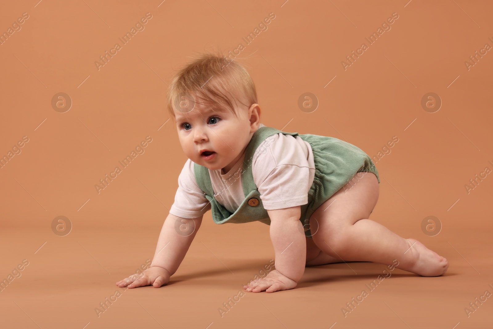 Cute little baby crawling on pale brown background Photo of Cute little baby crawling on pale brown background