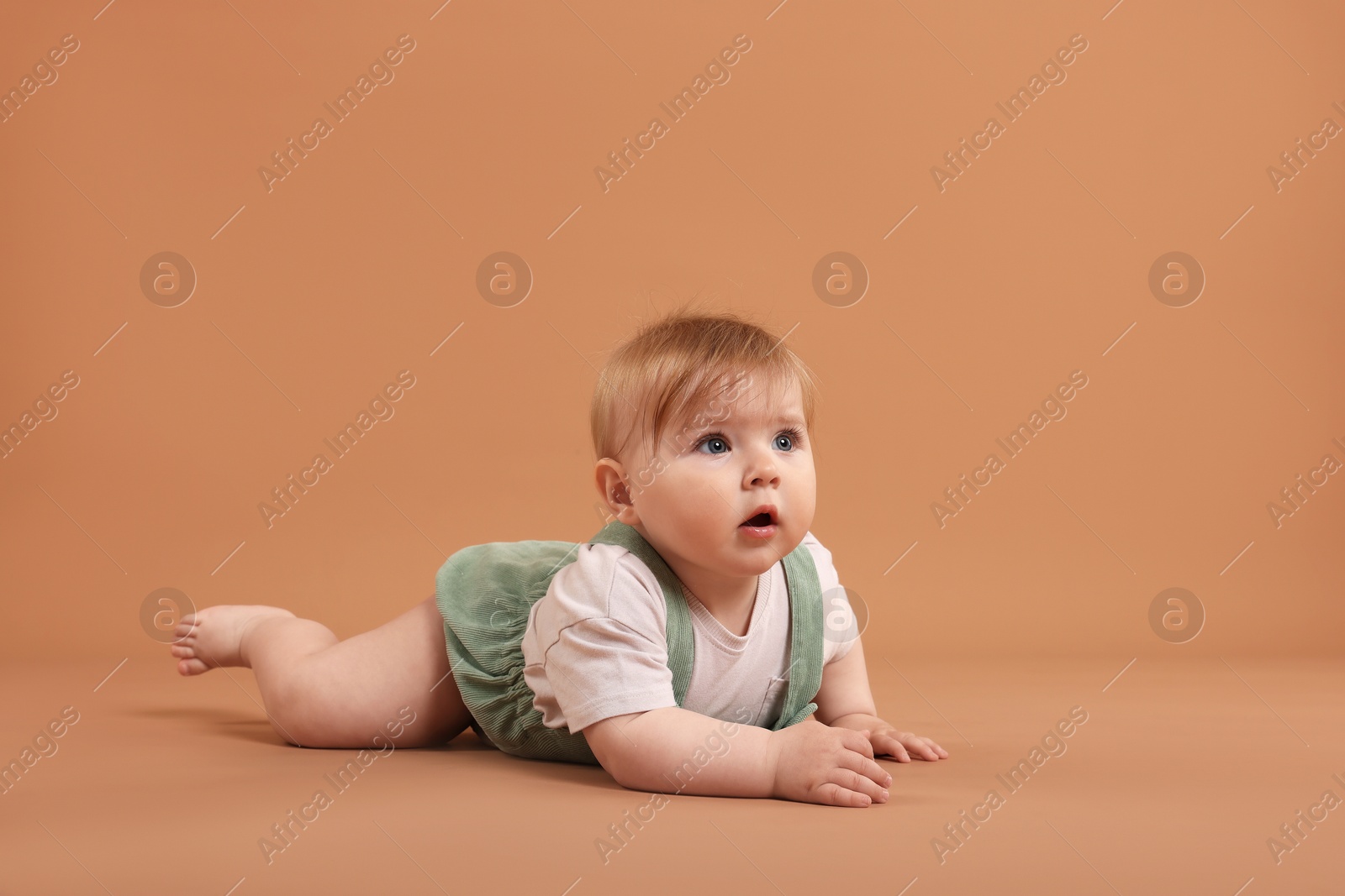 Cute little baby on pale brown background, space for text Photo of Cute little baby on pale brown background, space for text