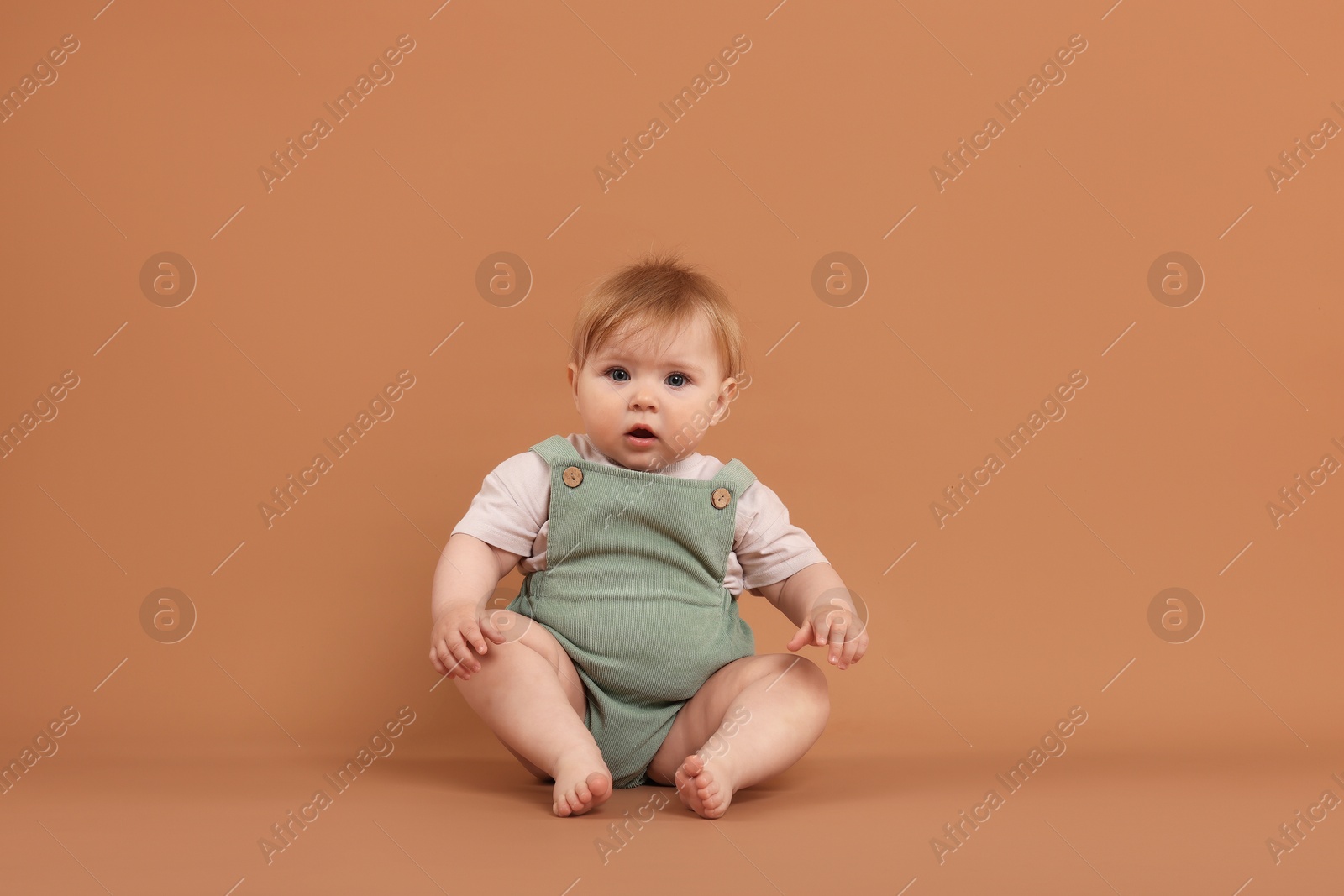 Cute little baby on pale brown background Photo of Cute little baby on pale brown background