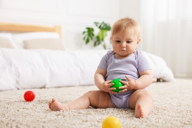 Photo of Cute little baby playing with toys on floor indoors, space for text