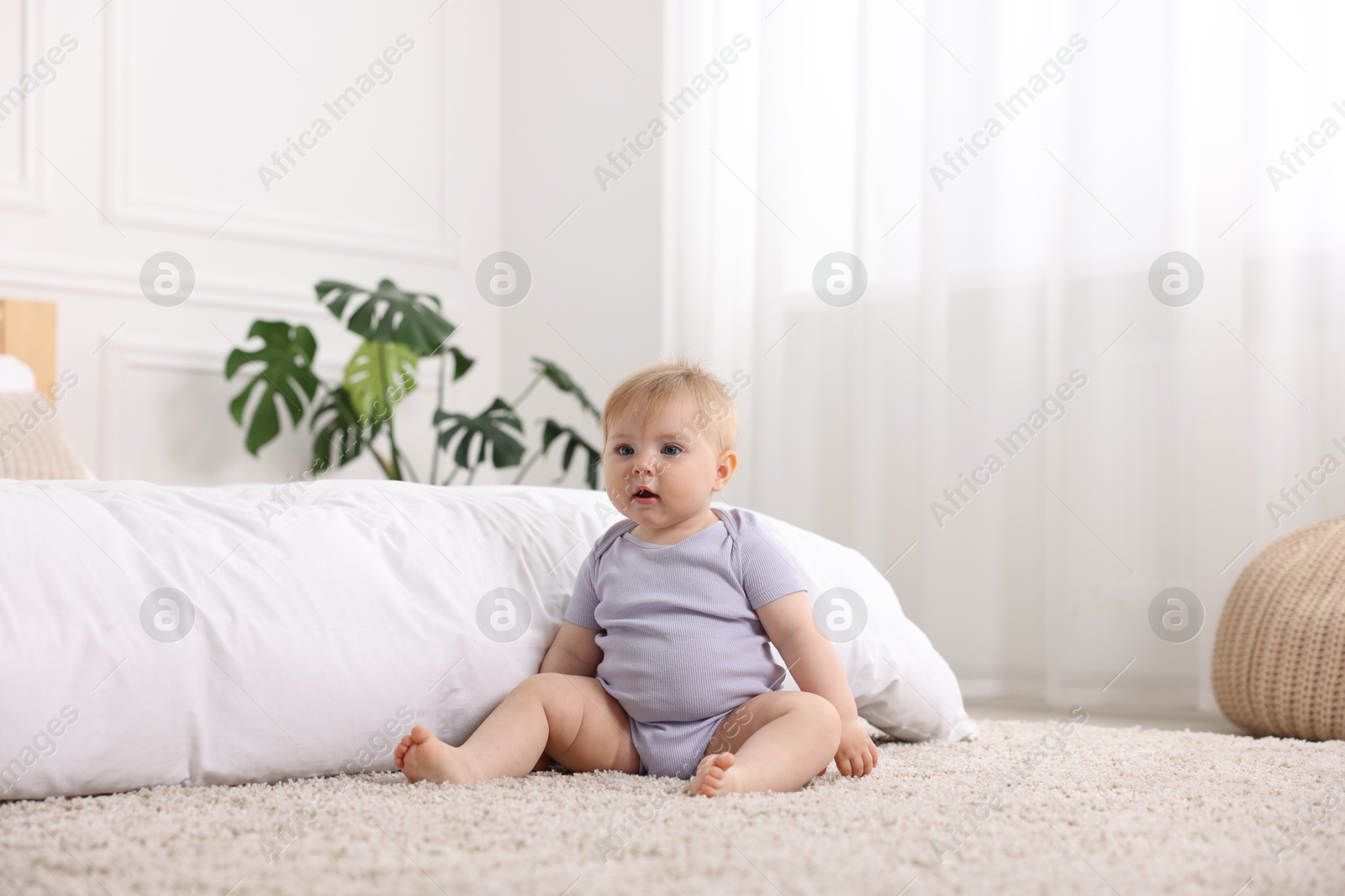 Cute little baby near bed at home Photo of Cute little baby near bed at home