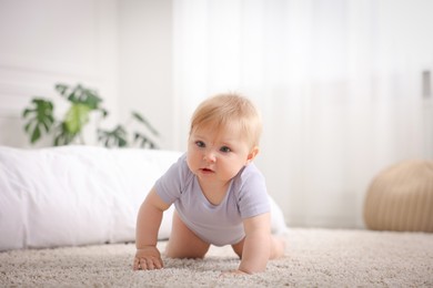 Photo of Cute little baby crawling on floor at home