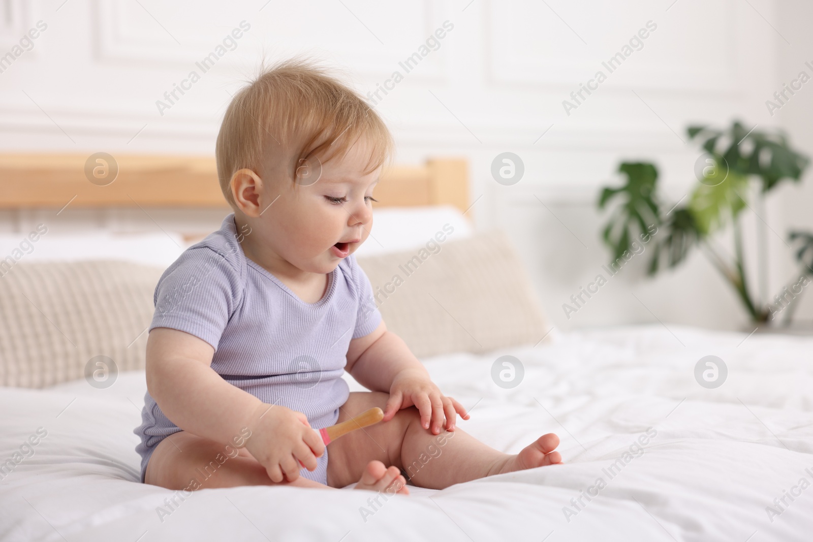 Cute little baby on bed at home, space for text Photo of Cute little baby on bed at home, space for text