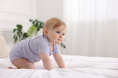 Photo of Cute little baby on bed at home, space for text