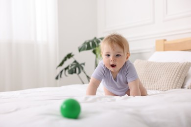 Photo of Cute little baby on bed at home, space for text