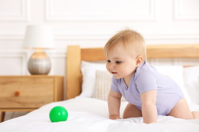 Photo of Cute little baby on bed at home, space for text