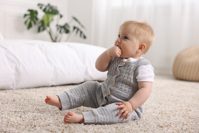 Photo of Cute little baby on floor at home
