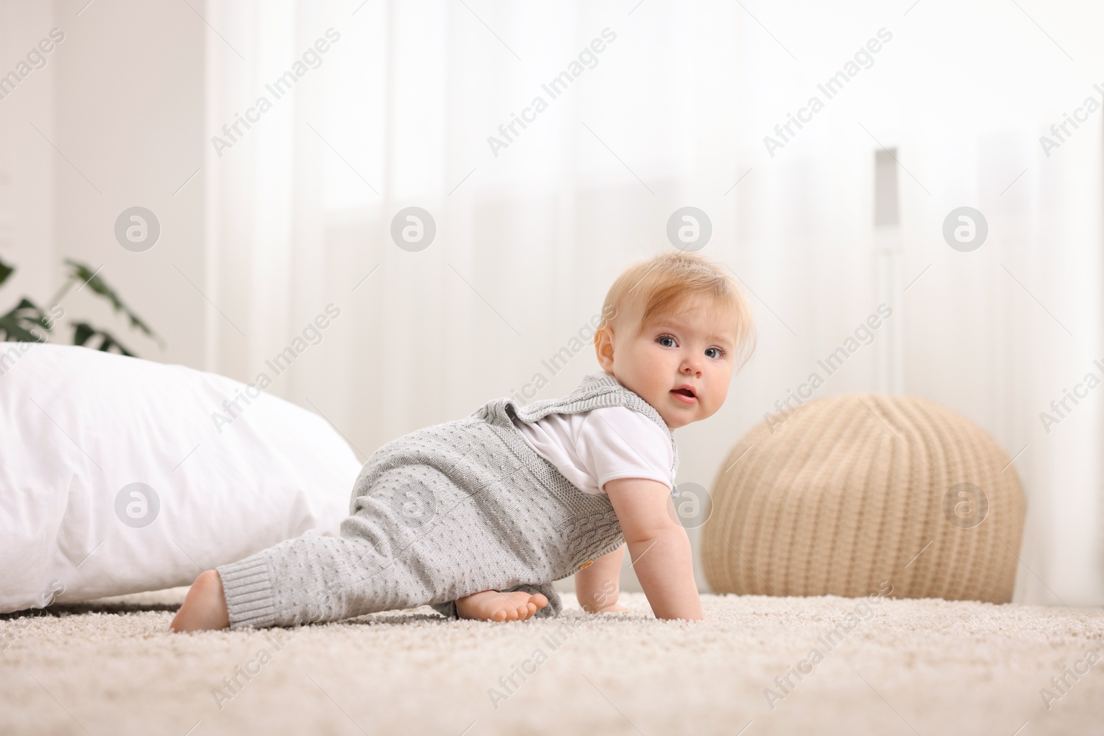 Cute little baby crawling on floor at home Photo of Cute little baby crawling on floor at home